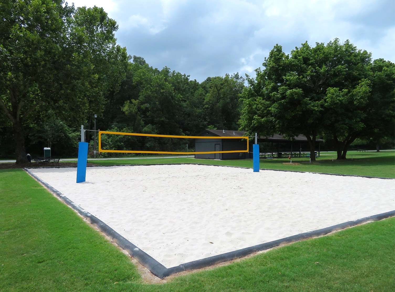 Sand volleyball court with pavilion in the background